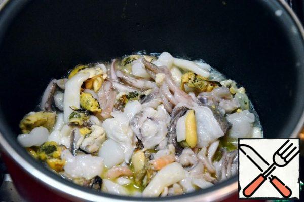 Defrost the seafood cocktail and drain the liquid. Heat the oil in a wide frying pan, fry the seafood for 2-3 minutes on high heat and set aside.
