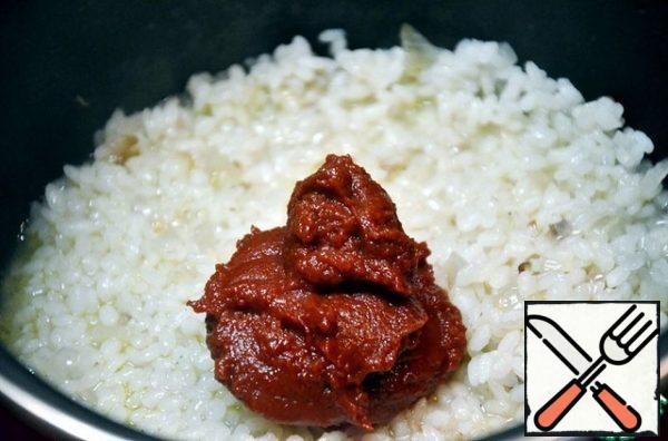Pour boiling water over the rice so that it covers the rice on the finger. Reduce the heat to medium, add salt. The total cooking time is about 20 minutes. After adding water, rice should not be stirred. Add tomato puree or crushed tomato pulp.
