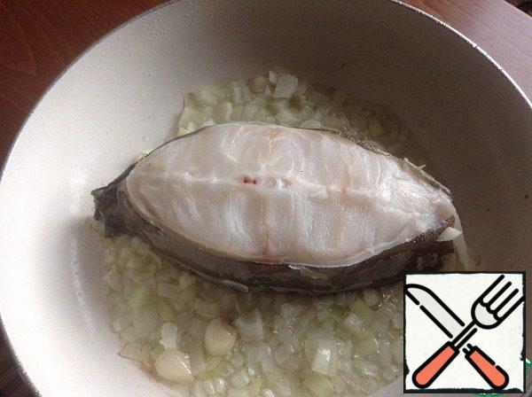 So.
We take the frying pan on which we will serve the dish,
put it on the fire, pour olive oil - about 3 tbsp
. l. Put the steak from the lancet fish in the center.
On the sides of it, fry finely chopped onion and a clove of garlic.