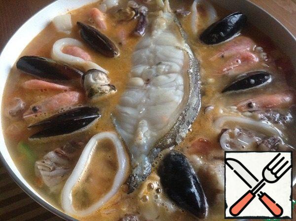 Put it on top of the seafood. Everything you have in stock.
I ordered a sea cocktail, some mussels and a handful of shrimp.
The amount is arbitrary - it all depends on your taste.
We leave our paella to cook on low heat until the rice absorbs all the liquid. It's about 20 minutes.