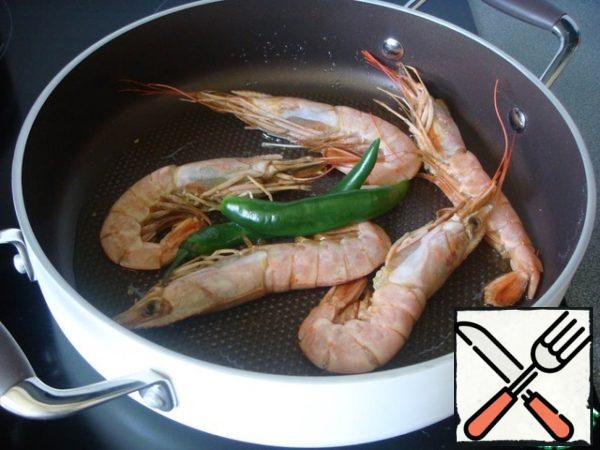 When the garlic is browned, remove from the pan and add the ingredients that require the longest cooking. I had raw very large shrimp that would not have had time to cook in a minute, so I pre-fry them for half a minute on each side. Thus, they also flavor the oil, and on the other hand, they themselves are saturated with fragrant oil. I leave a few large shrimps untouched to decorate the dish, plus this way they retain their juiciness.