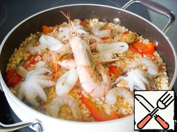 Next - octopuses, cuttlefish and raw shrimp, then squid.
* Since paella is usually served directly in the pan where it was cooked, it makes sense to spread seafood decoratively.
