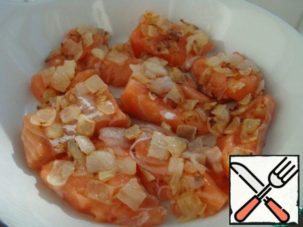 In a greased form with a diameter of 24 cm, put the salmon fillet cut into small slices, fried onion,
