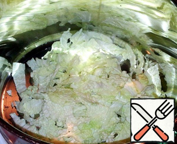In a large bowl, chop the cabbage.
