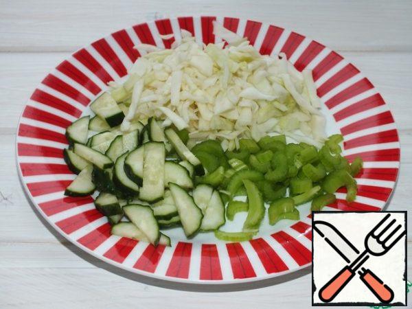 In the meantime, you need to chop cucumbers, cabbage and celery.
