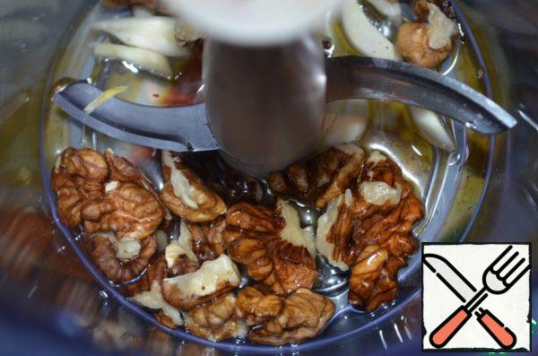 Grind the nuts and garlic with butter in a blender.
