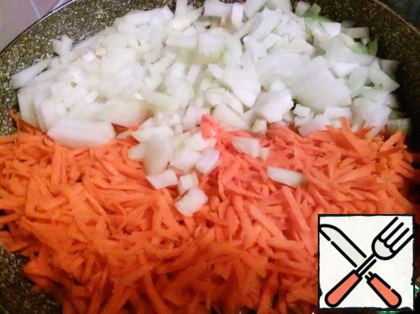 Grate the carrots on a coarse grater, chop the onion finely. Put everything in a large frying pan, fried in 100 milliliters of oil.
