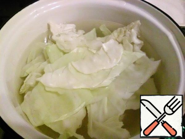 Remove a few leaves from the cabbage and steam them in boiling water until soft.