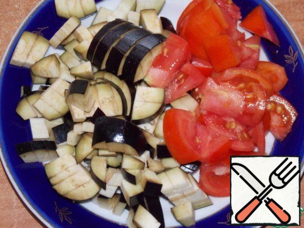 Cut eggplant and tomatoes.
