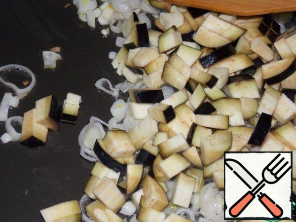 Fry the onion and eggplant in vegetable oil until half cooked.

