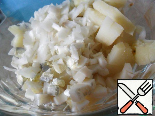 Boil potatoes and eggs, peel and cut into cubes. Finely chop the onion.
