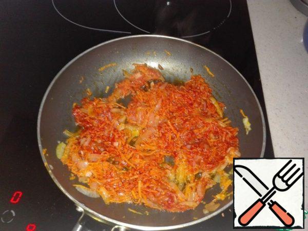 Grate the carrots on a fine grater and send it to the onion. As soon as the carrots change color, add a tablespoon of tomato paste.
