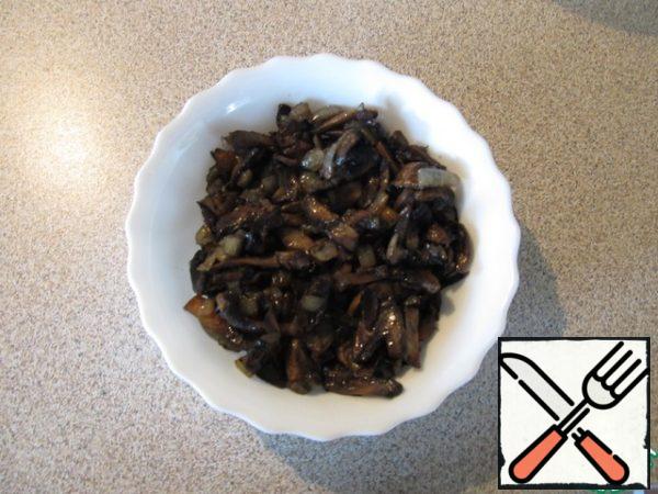 Cut the mushrooms into slices, diced onions and fry in sunflower oil until cooked (but not fried). Then you need to make the oil with mushrooms glass. I put the mushrooms in a colander and put a plate on the bottom.

