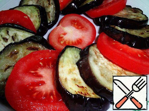 Spread the vegetables on a plate, alternating cooled eggplants and tomatoes. Do not add salt.