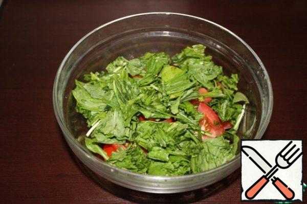 Slice the tomatoes and tear the arugula by hand.

