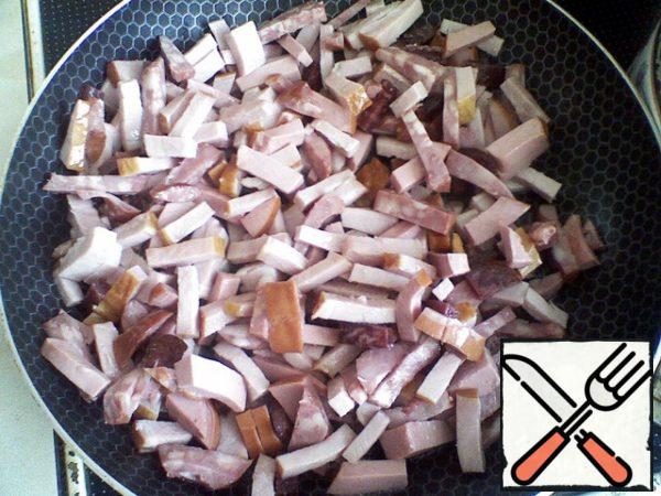Boil the chicken fillet until tender, cool the meat and cut it into pieces.
Prepare the sausage and meat collection. Cut the sausage and carbonate into cubes.