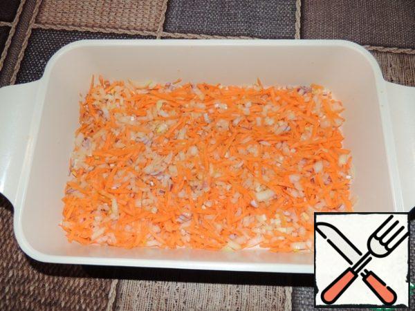 Finely chop the onion and carrot (I grated the carrots on a coarse grater), mix and put half of the resulting amount of vegetables in a high baking dish, make a kind of pillow.
