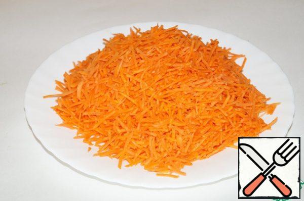 Wash, peel, and grate the carrots on a coarse grater.
