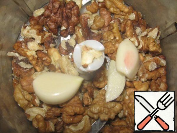 In a blender, chop the nuts and garlic.
