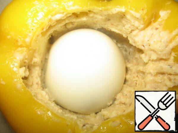 Boil hard-boiled eggs. Fill the resulting mass with peppers, insert an egg into the middle.
