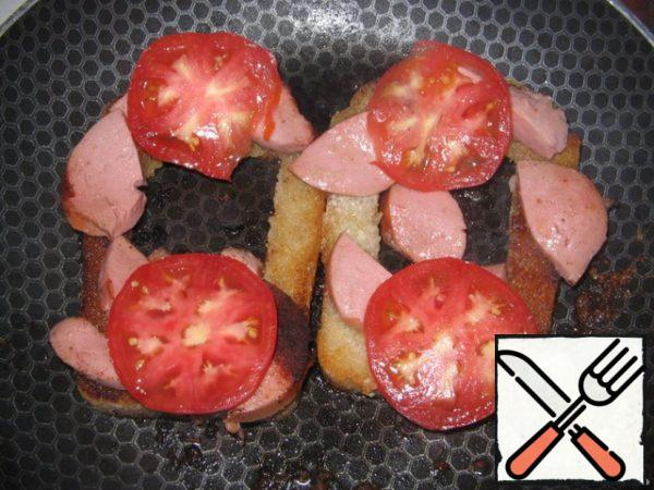 Remove the sausage from the middle (I put it there to fry) and put it on the edge of the bread. Lay out the tomatoes, cut into rings.
