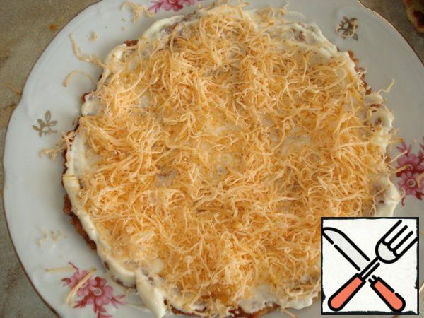 Assemble the cake. Brush the pie with mayonnaise and sprinkle with cheese.
