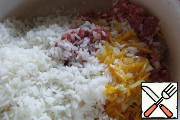 Put the minced meat in a bowl, add part, about half, onions and carrots, boiled rice, salt and spices.
