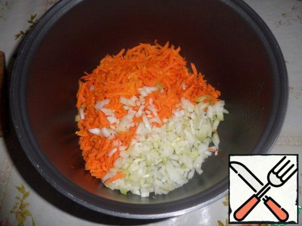 Pour vegetable oil into the bowl of the slow cooker. Spread the onion and carrot. Mix it.
