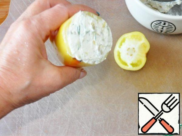 Tightly stuff the peppers with cheese mass with cucumber. Put the snack in the refrigerator.
