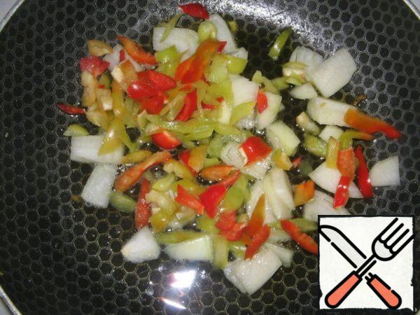 The remaining onions and the tops of peppers cut into strips are fried together.