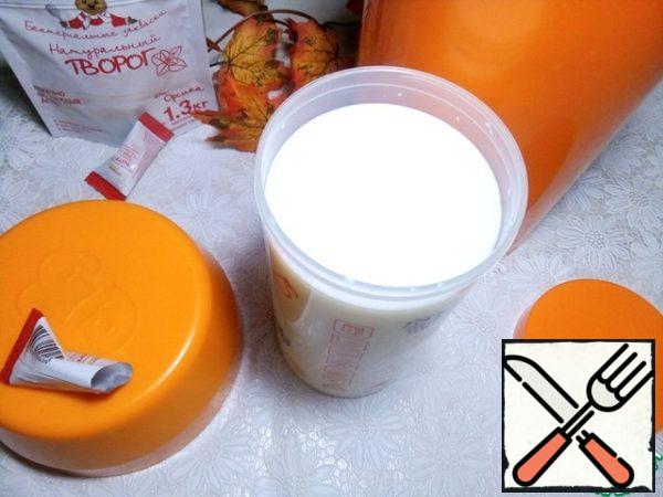 Pour milk and cottage cheese starter into a glass of scalded boiling water from a yogurt thermos, mix well.
