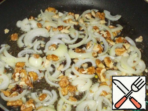 Heat the vegetable oil in a frying pan and fry the onion and nuts.
