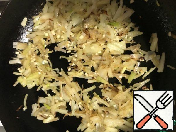 Next, I suggest a way to prepare such a side dish. It is assumed that the billet was frozen.
Pre-defrosting is not required.
Peel and slice the onion (in half rings or feathers, as I like). Chop the garlic.
Heat the oil in a frying pan, fry the garlic and onion (until transparent).