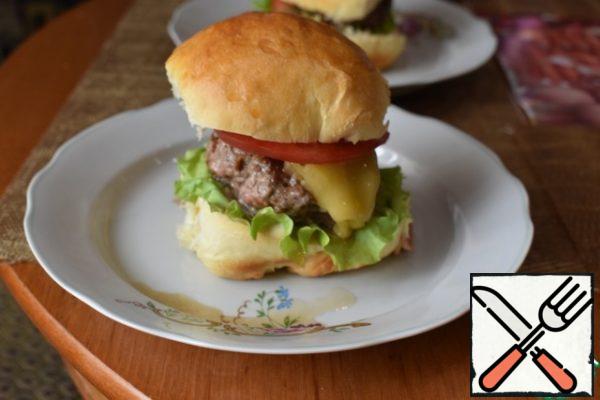 Picking a Burger. Bun cut into 2 parts. The upper part is smeared with ketchup, the lower with mustard mayonnaise. On Mayo, put lettuce, marinated onion, chicken, slice tomatoes and top bun.