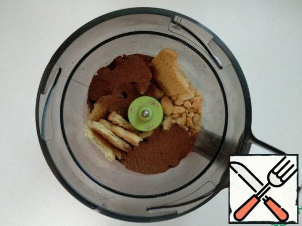 Cookies with cocoa are crushed in a blender.
