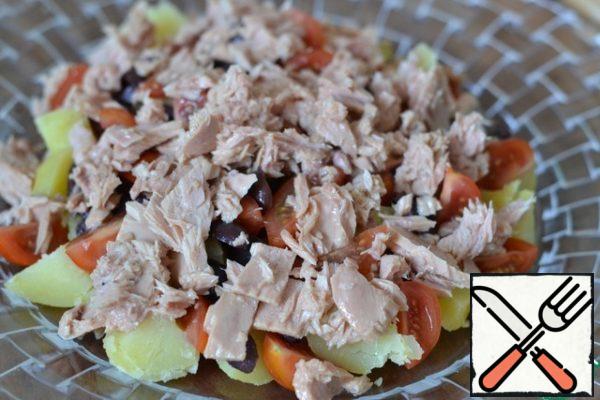 In a separate bowl mash with a fork tuna. Do not drain oil.
Put on top of the salad.