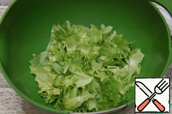 In a large bowl, cut the lettuce leaves by hand into pieces.
