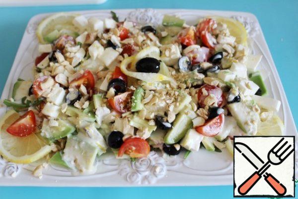 Then pour the dressing, sprinkle with nuts and decorate with lemon slices. The salad is ready.