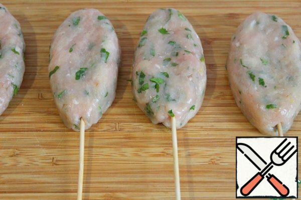 Moistening your hands with water or vegetable oil, make kebabs.
We insert the stick, slightly pressing the shish kebab to it.
Spread on a silicone mat or a greased baking sheet.
Bake for 10-12 minutes - focus on your oven and do not dry out!