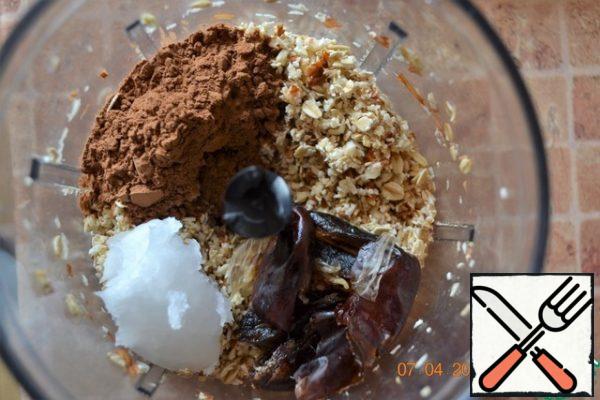Grind the oat flakes and almonds in a blender. By the way, I pre-soaked the nuts in room temperature water for at least 2 hours. This contributes to better assimilation and digestion of nuts. Wash the dates. Add cocoa powder, coconut oil and dates to the flakes and almonds and chop again.
