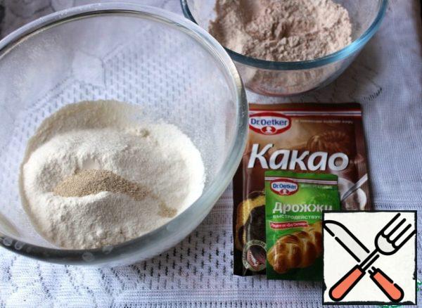 Take 2 bowls. In the first sift flour, in the second - flour with cocoa. Add 1/2 tsp of dry yeast to each bowl and mix.
