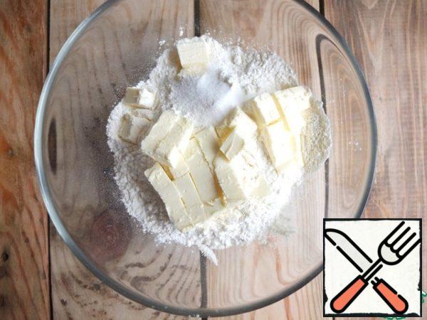 Sift 500 g of flour into a bowl. 50 g remained on the hem during the cutting of the dough.
Add salt and softened butter.
Chop into crumbs with your hands.