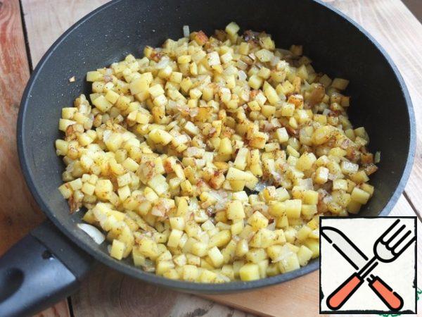While the dough is "resting", prepare the filling.
Finely chop the onion and potatoes. Fry in a small amount of vegetable oil until golden brown.
Add salt and pepper (here you can omit it and season the filling after adding minced meat).

