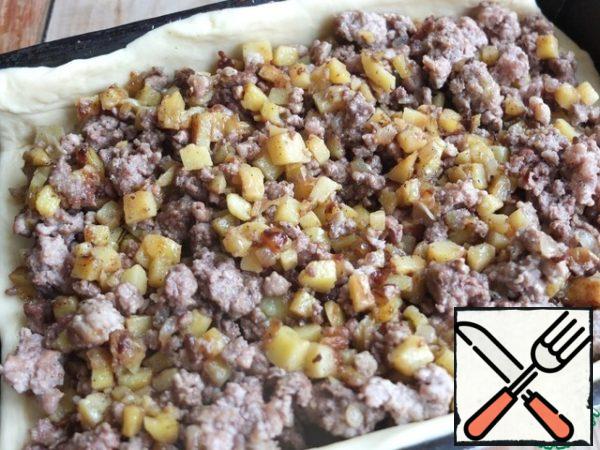 At this stage, you can go in two ways: form pies from the dough or cook one large cake. It turns out no less delicious!
In the case of a pie, divide the dough into two parts. Roll out one part thinly, put the dough into a mold, form the sides. Put the filling on top.