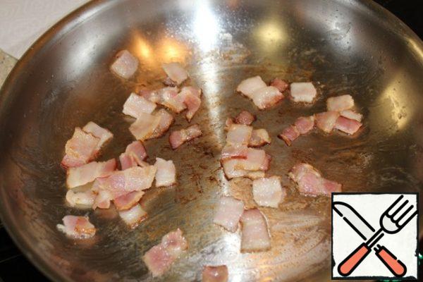 In a dry frying pan, fry the bacon over medium heat, the fat should melt and the pieces crunch. I spread the bacon on a paper napkin.
