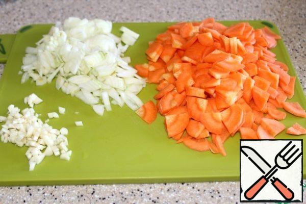 Cut the carrots twice lengthwise, and then into thin slices about 3 mm thick. Finely chop the onion and garlic.
