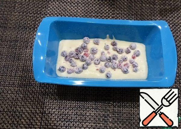 Grease the mold with vegetable oil and pour the dough in three steps, put the berries between the layers.
