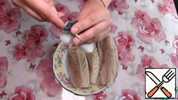 Now rinse each mackerel fillet under running water and dry with paper towels.
Pierce the fillet from the tail side at a distance of 1-2 cm from the edge and thread the thread folded 2 times into the hole.
