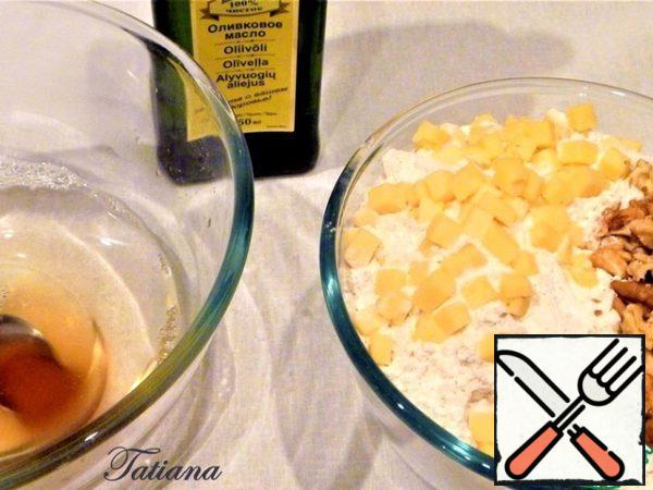 Prepare additional ingredients:cut the cheese into small cubes (5 * 5 mm.). Dry the nuts a little in the oven (I dried the nuts immediately after purchase -stored in a container with the lid closed in a dark, cool place), cut into large pieces with a knife. Mix two types of flour, sift into a bowl, add dry yeast, cheese, walnuts (set aside 1 tablespoon of nuts to sprinkle on top of bread before baking), mix. In a bowl for kneading dough (heat-resistant container = 2 liters), pour 300 ml. in hot (boiled) water, dissolve salt, add honey,
mix.
