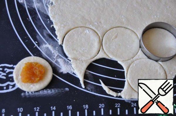 Cut out circles with a diameter of 5 mm. Put half a teaspoon of dried apricots in the middle of the mug.

